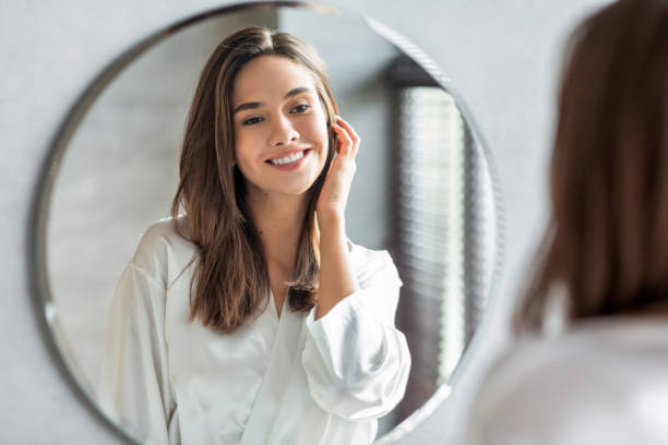Woman looking at the mirror happily